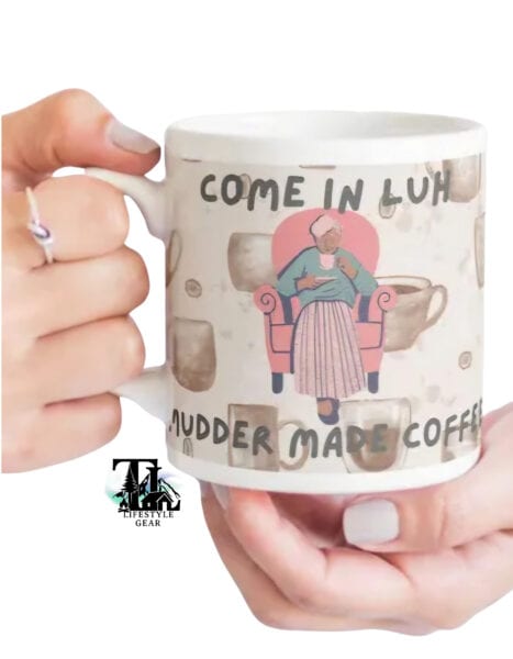 Newfoundland grandmother in a chair with a coffee mug. text reading come in luh mudder made coffee. white ceramic 15 oz mug