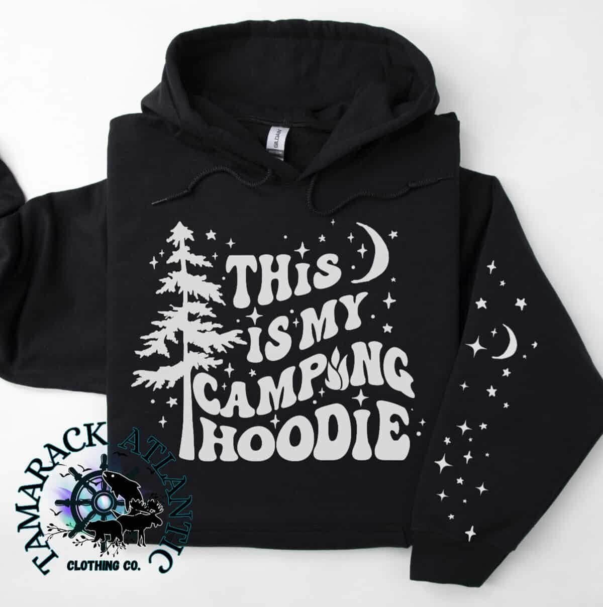 A shirt with the text, "This is my camping hoodie", a starry night background with a tamarack tree.
