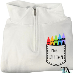 White quarter zipped sweatshirt with a pocket chest logo and colorful crayon designs. Customized with name or text for gifts for teachers, ECE and daycare workers.