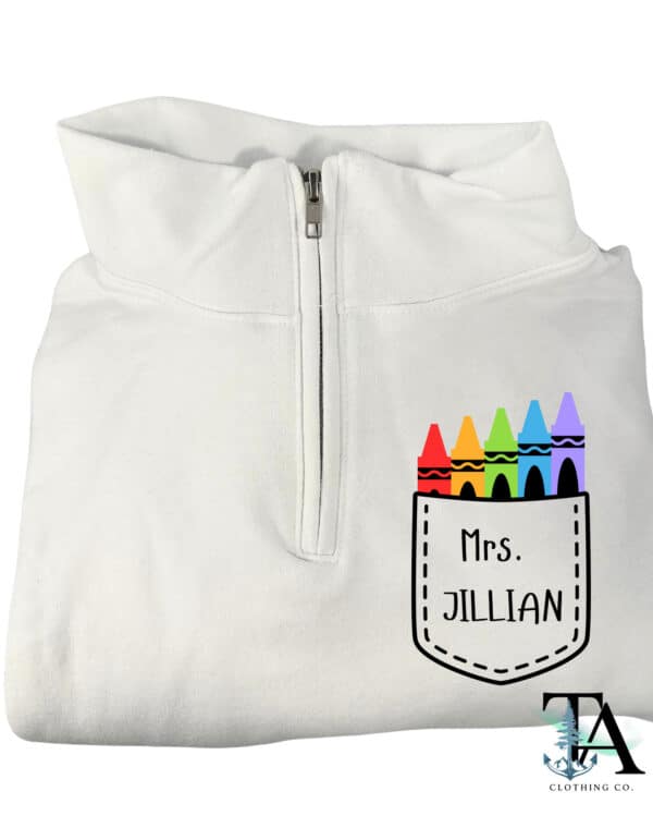 White quarter zipped sweatshirt with a pocket chest logo and colorful crayon designs. Customized with name or text for gifts for teachers, ECE and daycare workers.