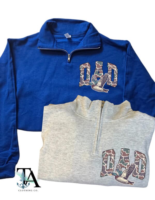 2 Quarter zipped sweatshirts with a front chest patch that says DAD in capital letters. The text contains a camo print and a wild duck flying underneath the letters. Great for fathers day gifts, birthday for dad and new dad gift.